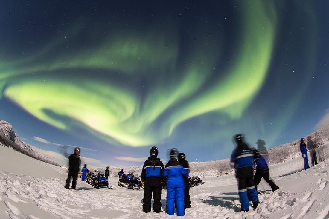 Business group participating in an outdoor snowmobile team building activity in Lapland